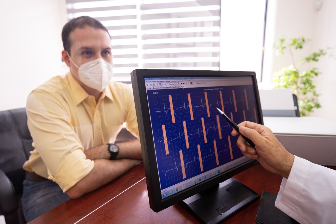 Médico revisando resultados de ECG junto a un paciente